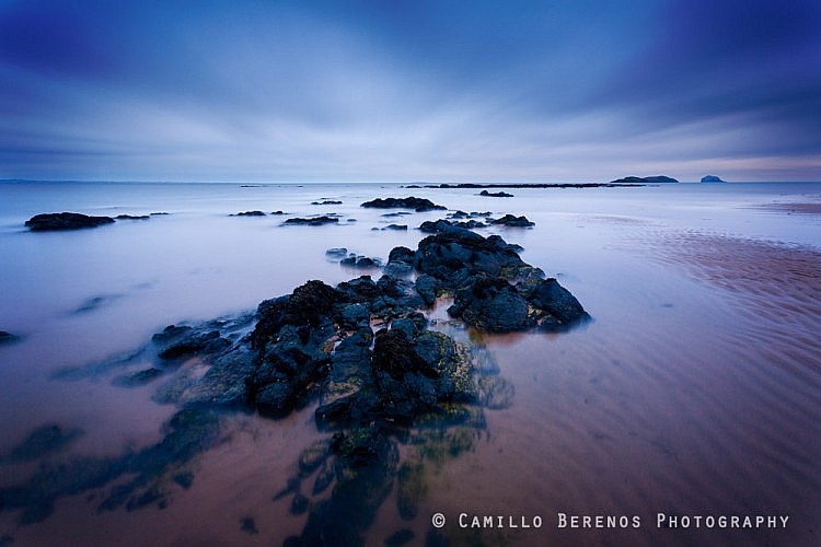 Cloudy conditions prevented a spectacular sunrise from happening, but the blue hour light in combination with the radiating clouds was wonderful. Yellowcraig Beach near North Berwick, East Lothian.