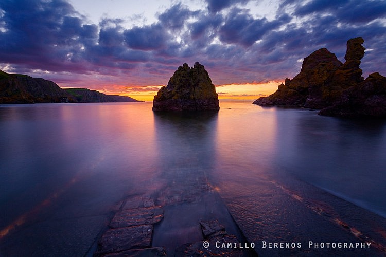 Jetty at St Abbs Head submerged at high tide during an intense sunset in summer.
