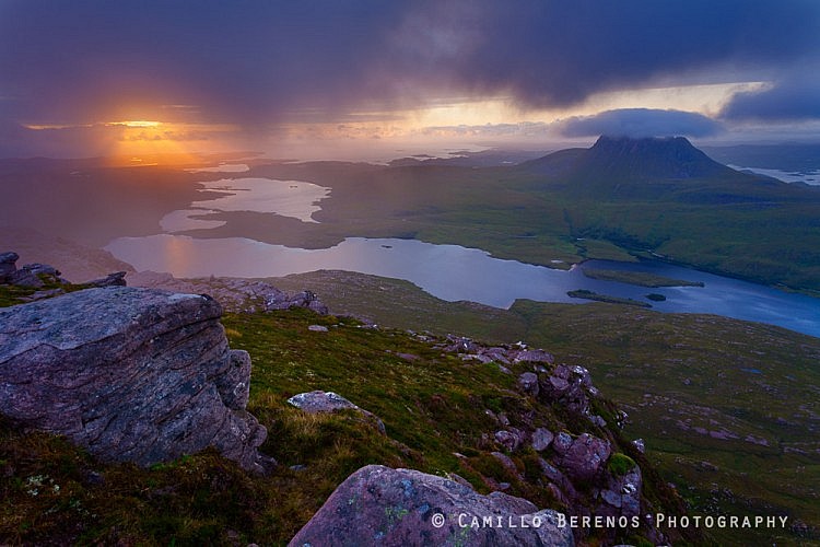 The sun was trying hard to break through the fast moving low-hanging clouds above Coigach and Inverpolly half an hour before sunset. Stac Pollaidh can be seen on the right with the sea on the left.