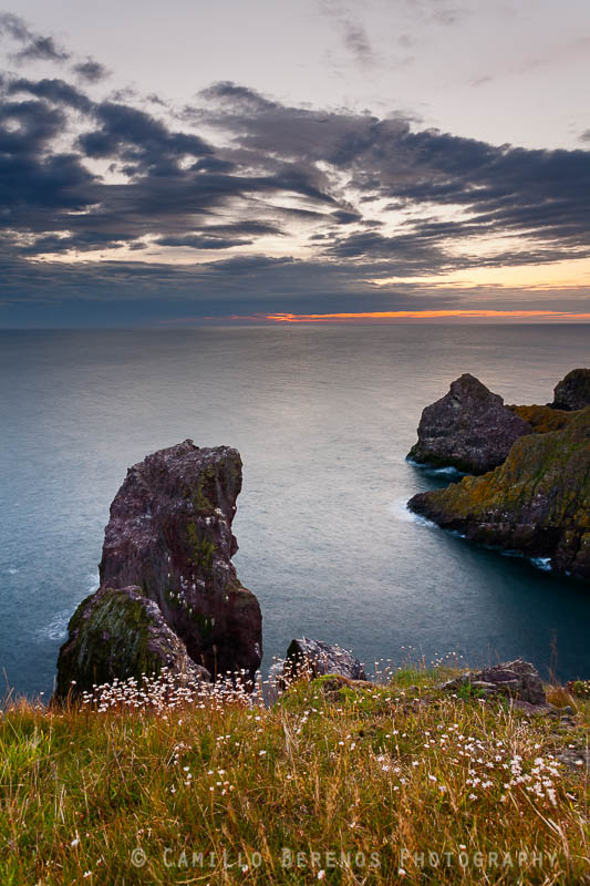 A sea stack and interestingly shaped cliffs at St Abbs head Nature reserve with sunrise imminent.